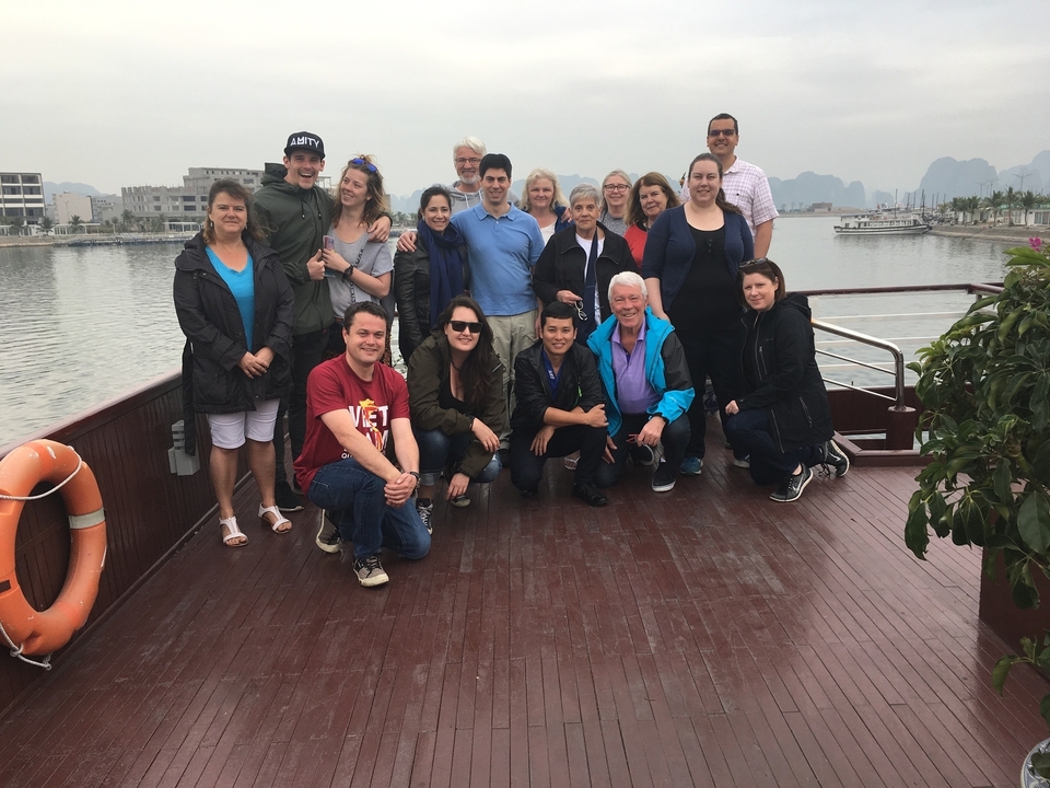 Groupe de personnes sur un bateau avec un arrière-plan montagneux.