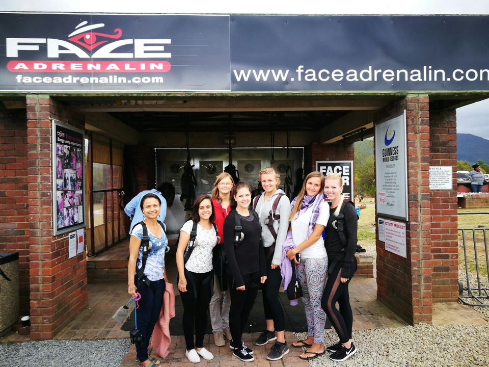 Groupe de personnes posant devant un panneau d'aventure.