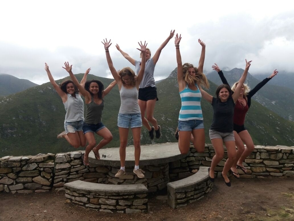 Un groupe de femmes sautant avec excitation sur un fond montagneux.