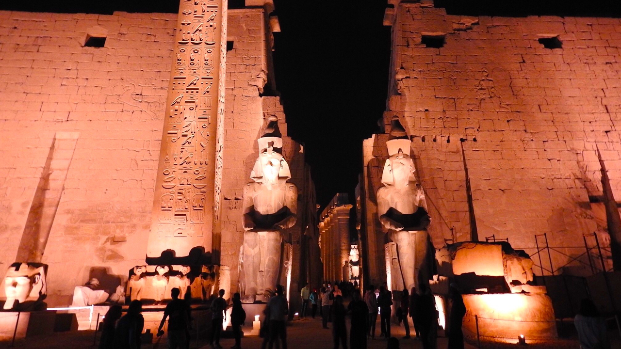Temple at night with illuminated statues.