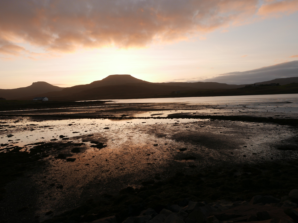 Coucher de soleil sur un paysage côtier se reflétant sur l'eau