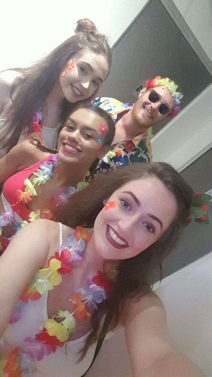 Close-up of people in colorful outfits smiling for the camera.