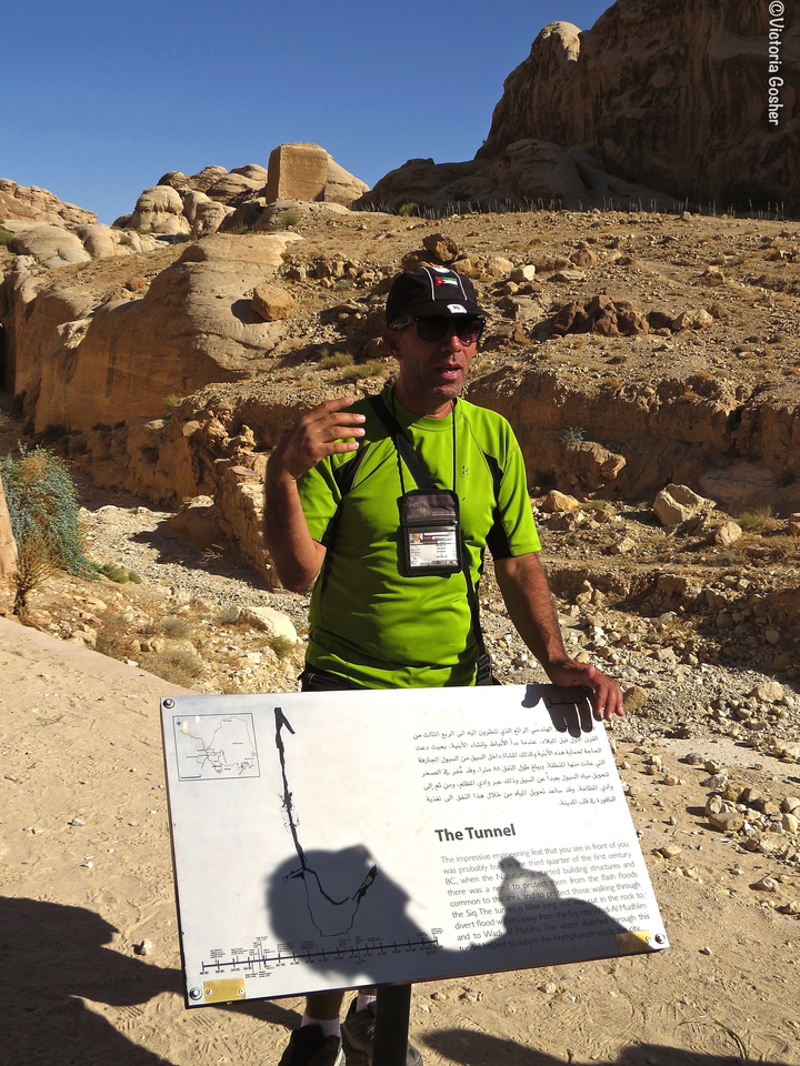 Guide explaining at a historical site with informative signage.