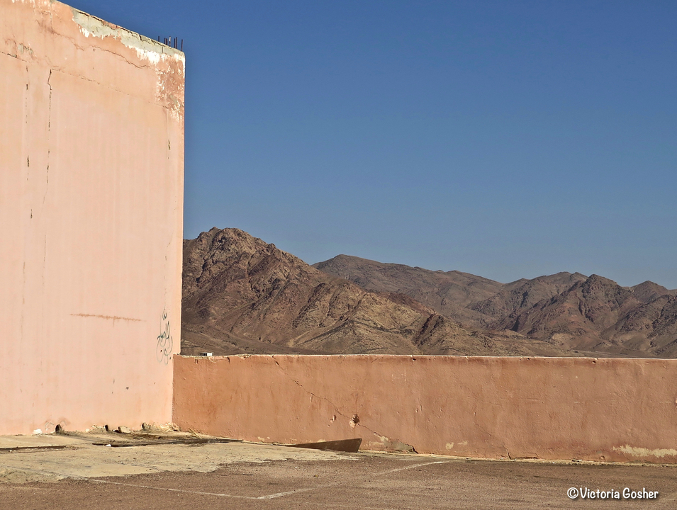 Montagnes et ciel dégagé vus par-dessus un mur.