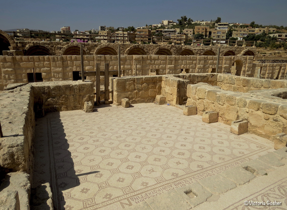 Ruines en pierre d'un ancien bâtiment avec un sol en mosaïque.