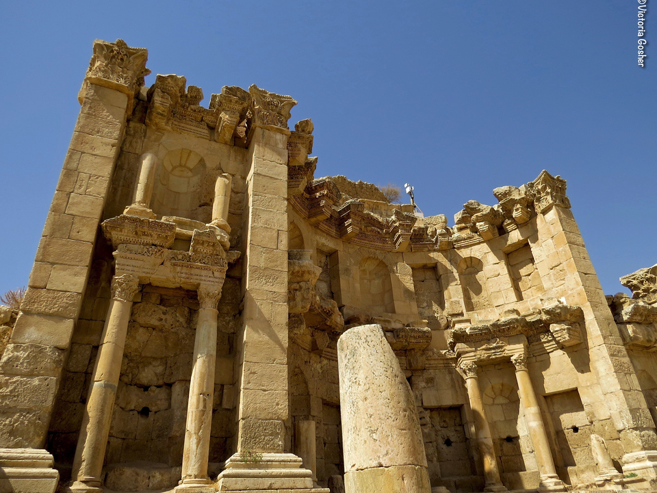 Ruines d'un ancien temple avec des colonnes ornées et un ciel clair.