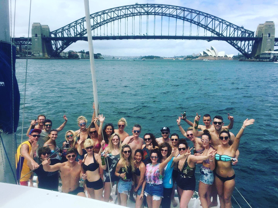 Large group photo with Sydney landmarks in the background
