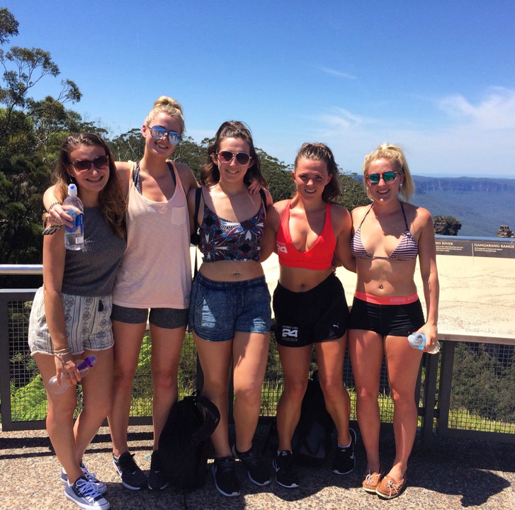 Group of women posing at a scenic viewpoint outdoors