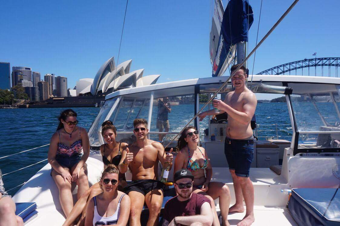 People enjoying on a boat with Sydney Opera House in the background.