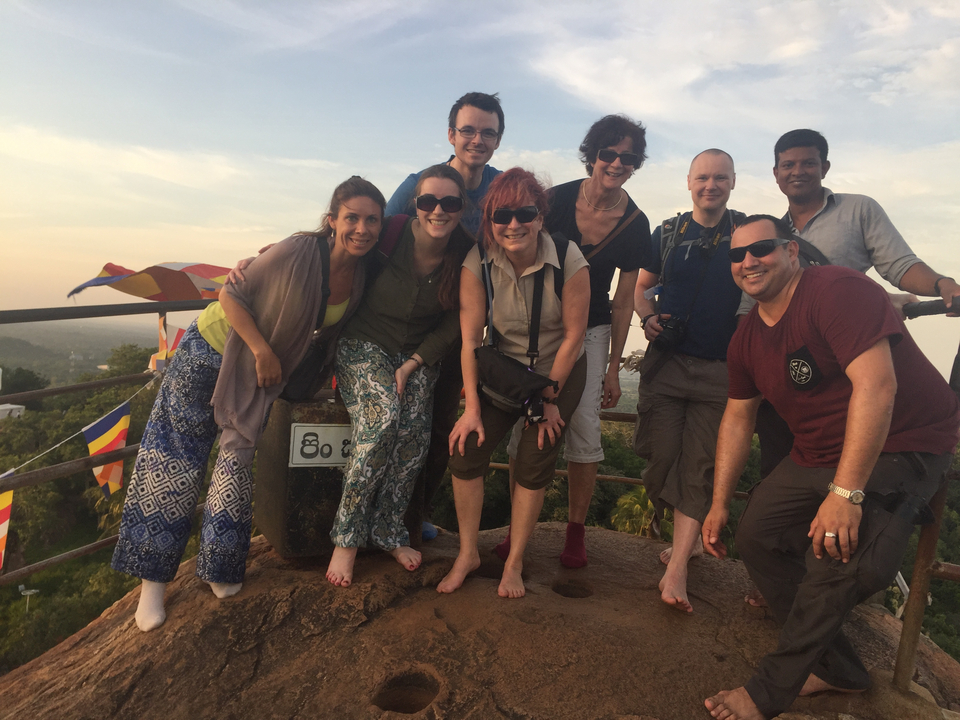 Groupe de personnes se tenant sur une colline et profitant de la vue.