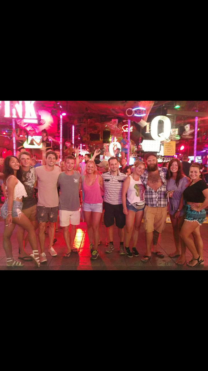 Group of people at a bar with vibrant lighting.
