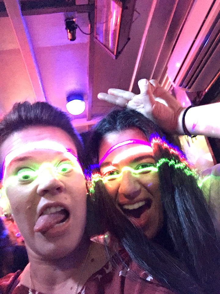 Deux personnes avec des reflets de néon prenant un selfie.