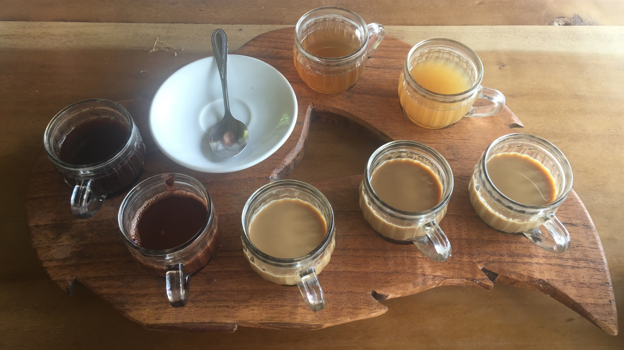 Plusieurs verres de boissons disposés sur un plateau en bois.