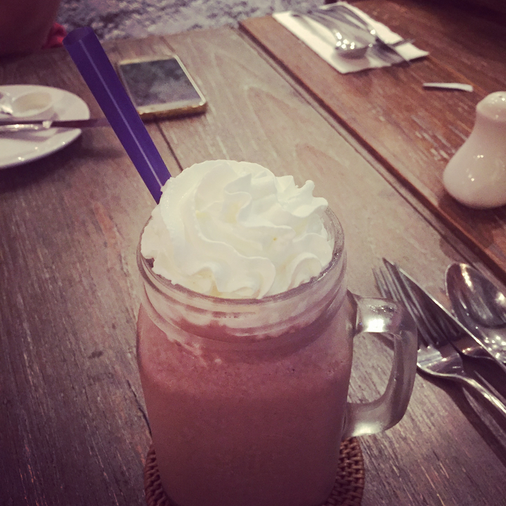 Un verre de dessert dans une tasse avec de la crème fouettée sur le dessus.