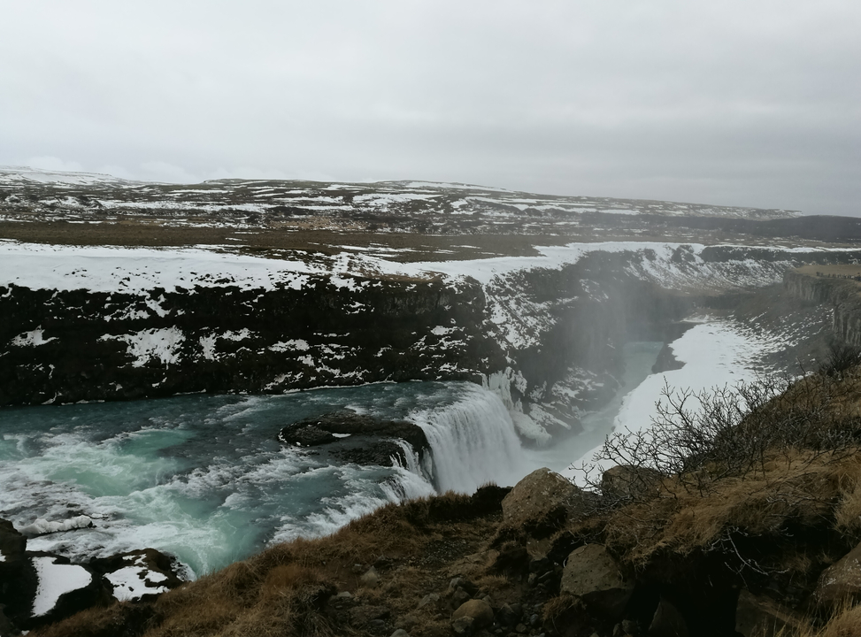 Large waterfall in a valley with snow