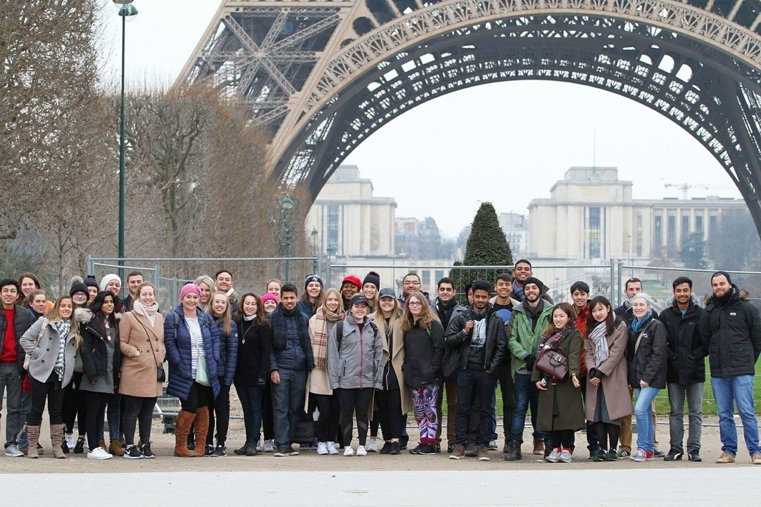 Large group posing in front of the Eiffel Tower