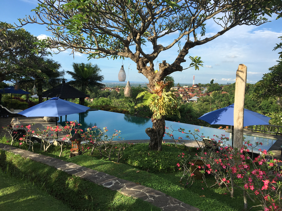 Beautiful garden view with an infinity pool and cityscape