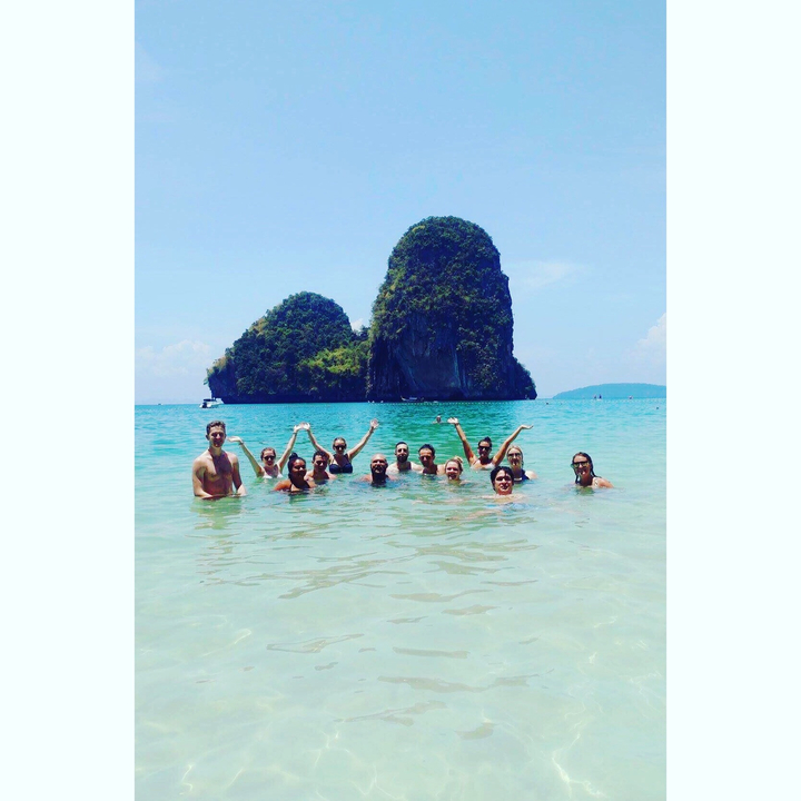 People enjoying the sea with a scenic island in the background.