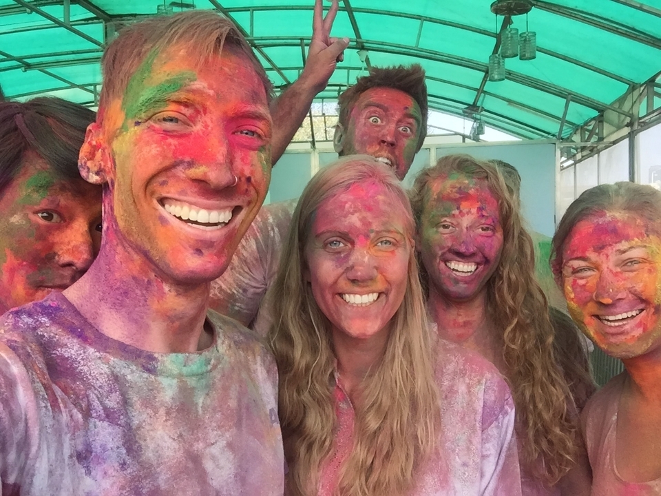 Un groupe célébrant Holi avec de la poudre colorée sur leurs visages.