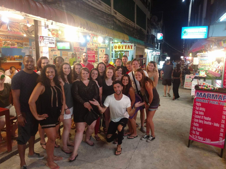 Group of tourists gathered at a night market.