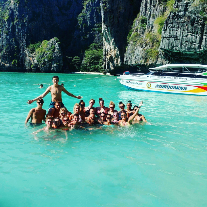 Group of people swimming in clear blue water.