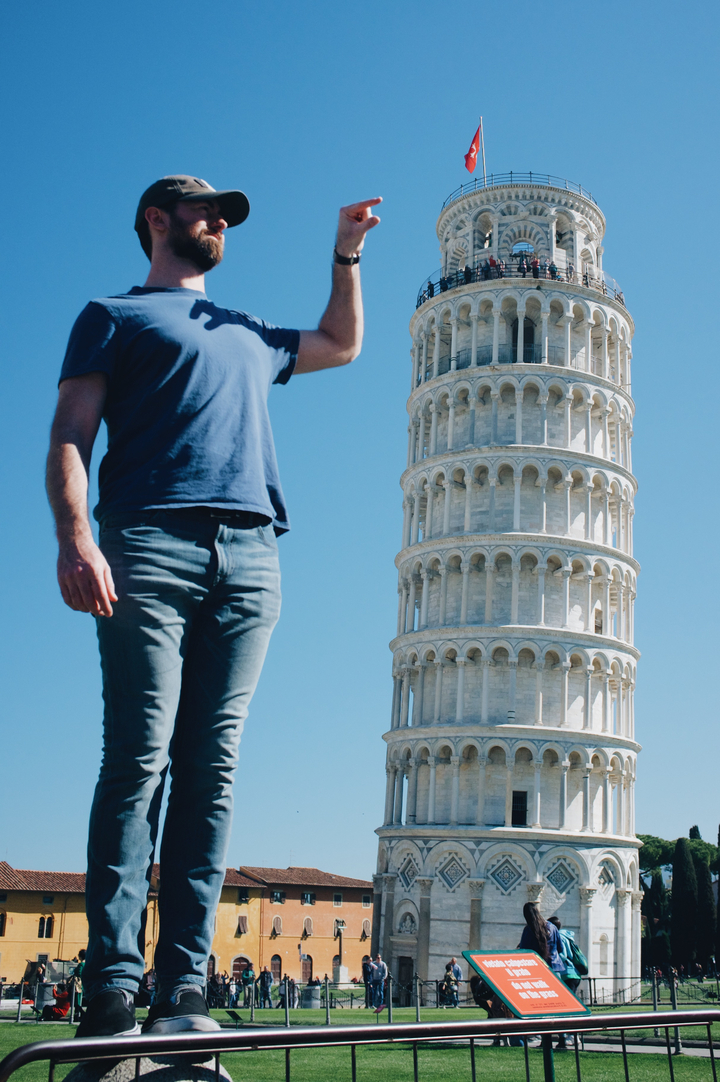 Gros plan d'une personne se tenant près de la tour penchée de Pise.