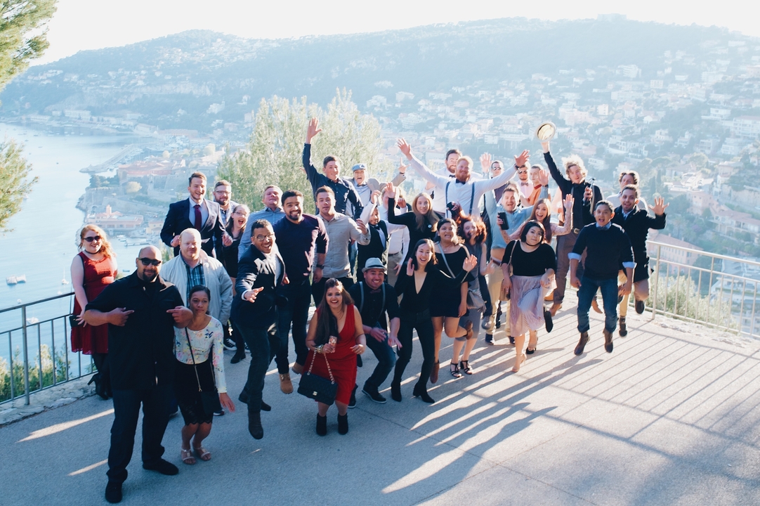 Grand groupe de personnes posant avec une vue pittoresque de la ville en arrière-plan.