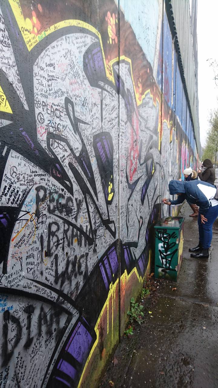 Mur de graffitis avec une personne prenant une photo.