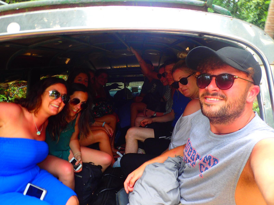 Group of people inside a vehicle, smiling and posing.