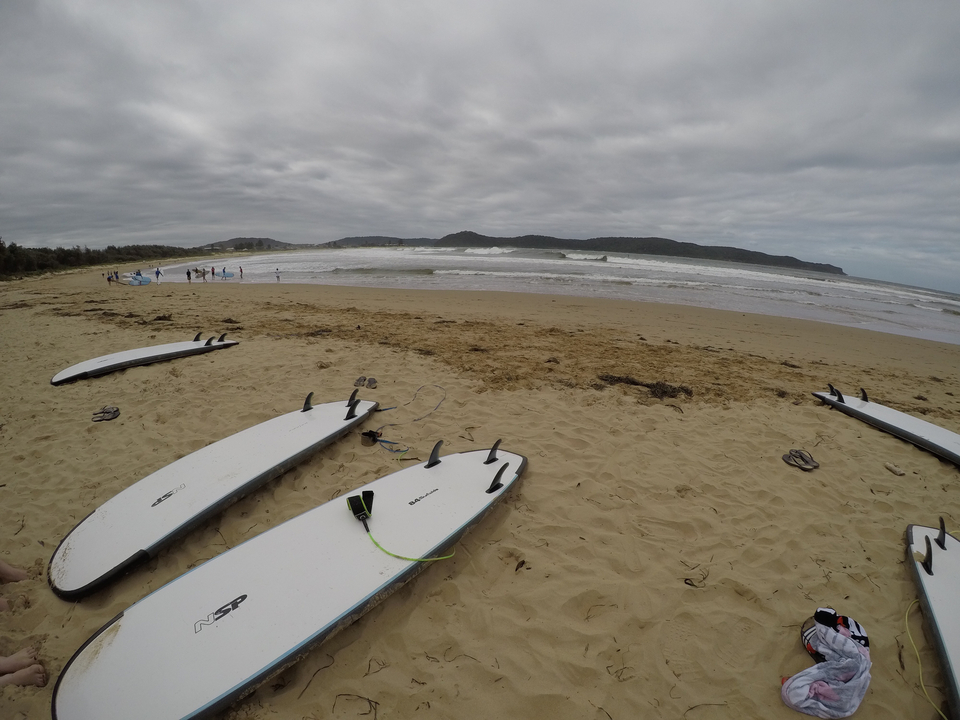 Beach with surfboards and waves.