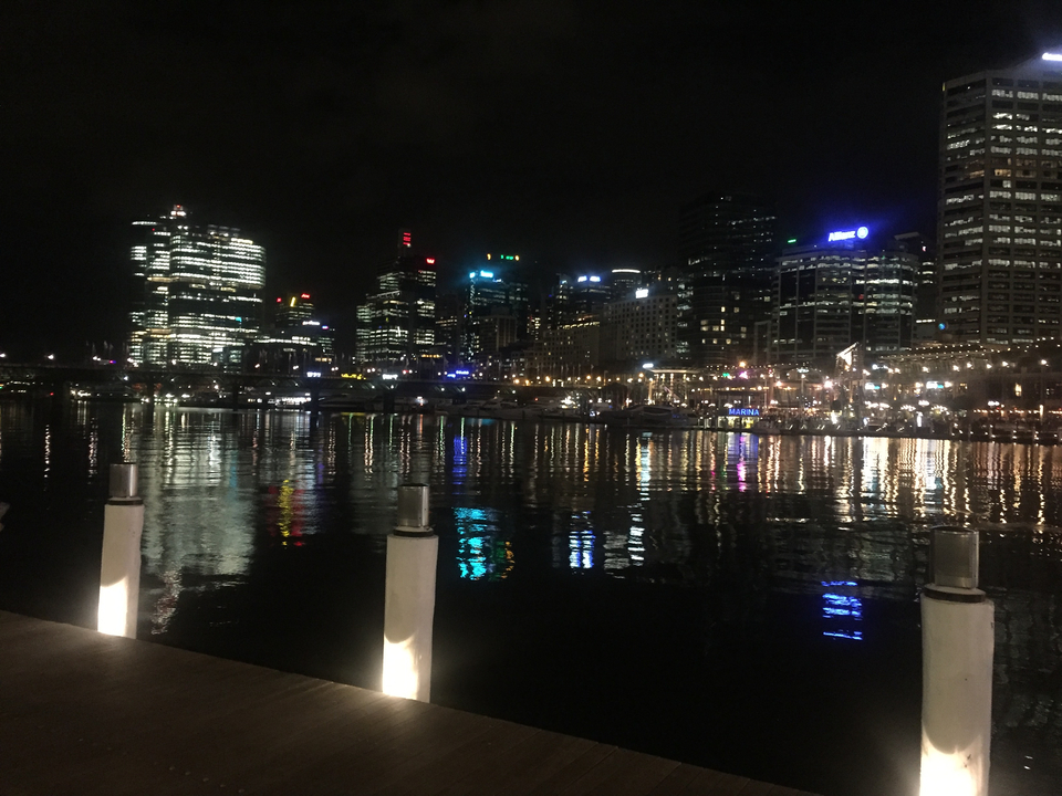 City skyline at night with lights reflecting on the water.