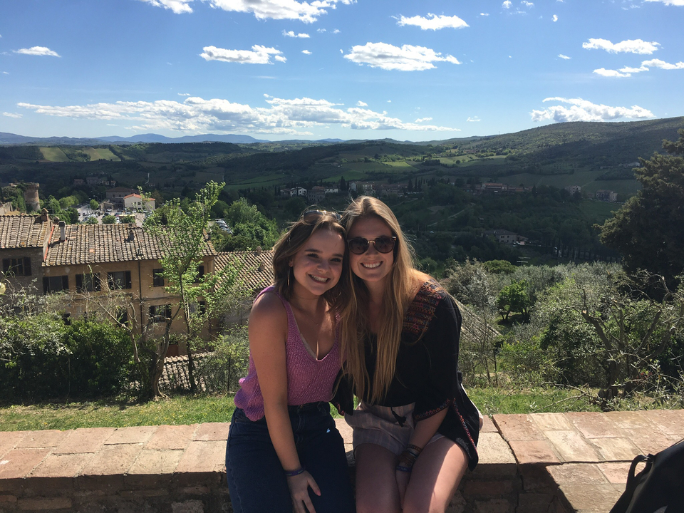 Deux amis assis sur un mur avec vue sur la campagne.