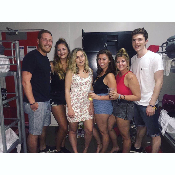 People posing in a dorm room with bunk beds.