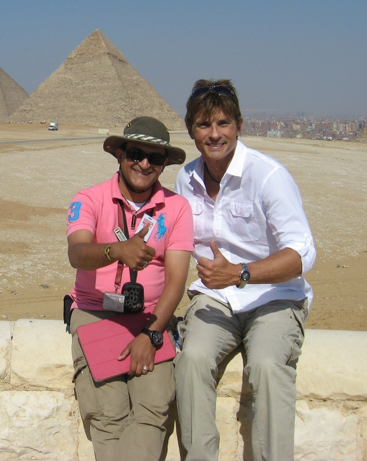 Deux hommes posant dans le désert en levant le pouce.