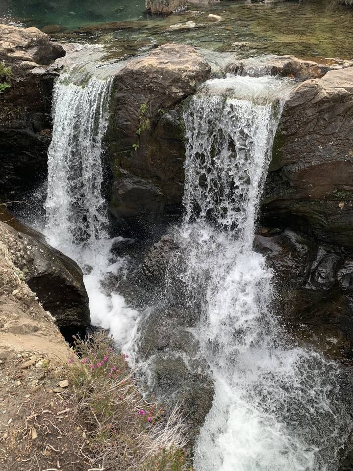 Cascade d'eau tombant sur des rochers dans un cadre naturel.