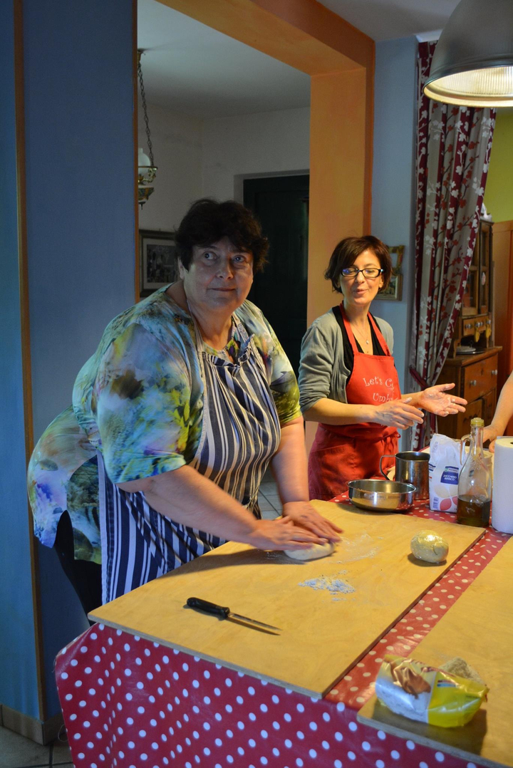 Deux femmes préparant des plats dans une cuisine.