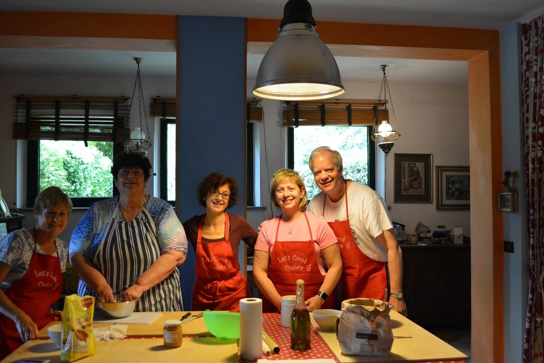 Groupe de personnes cuisinant ensemble dans une cuisine familiale.