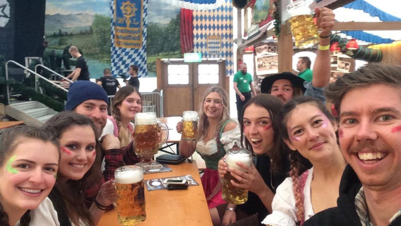 Groupe de personnes dégustant des bières à l'intérieur d'une salle décorée de manière festive.