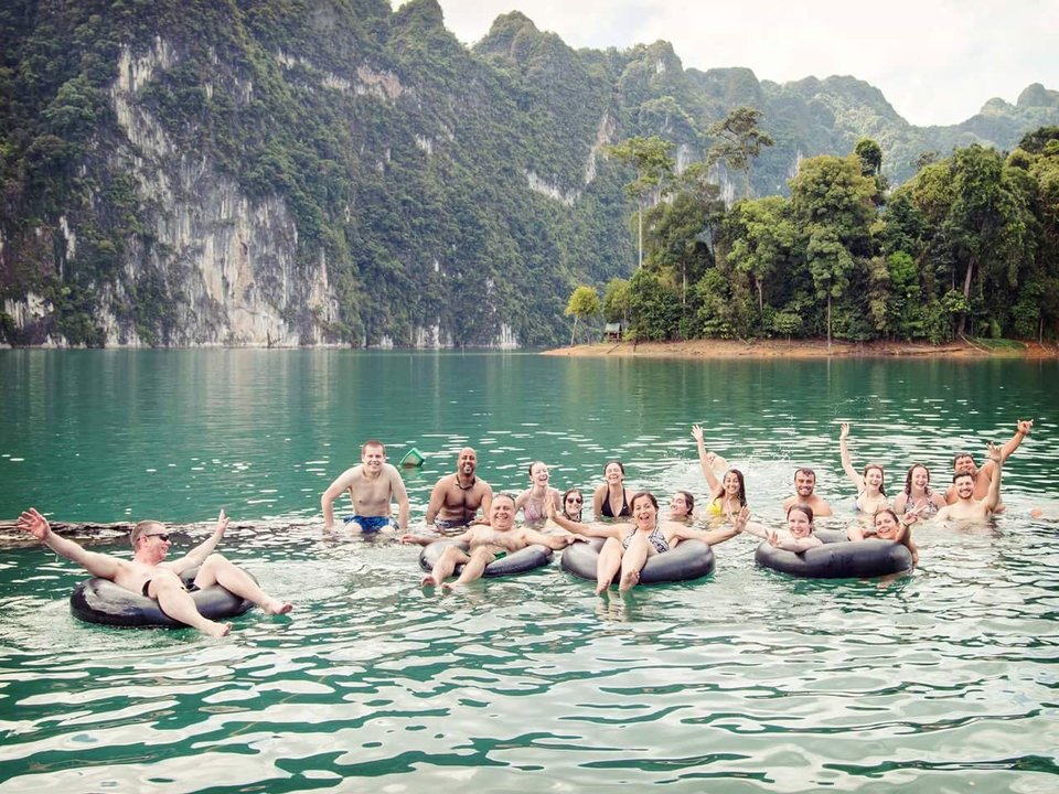 A large group floating with inner tubes on a body of water.