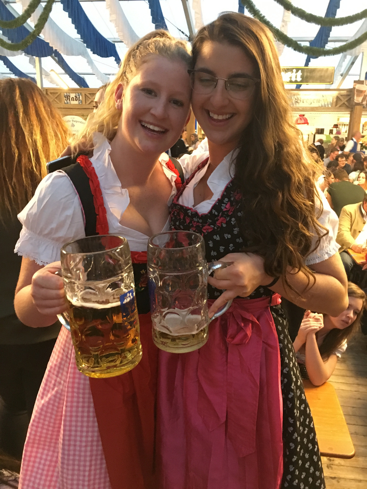 Gros plan sur des personnes en tenue traditionnelle tenant des chopes de bière.