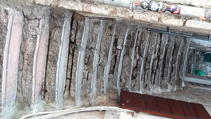 Marches en pierre à texture rugueuse sur un mur, inclinées.