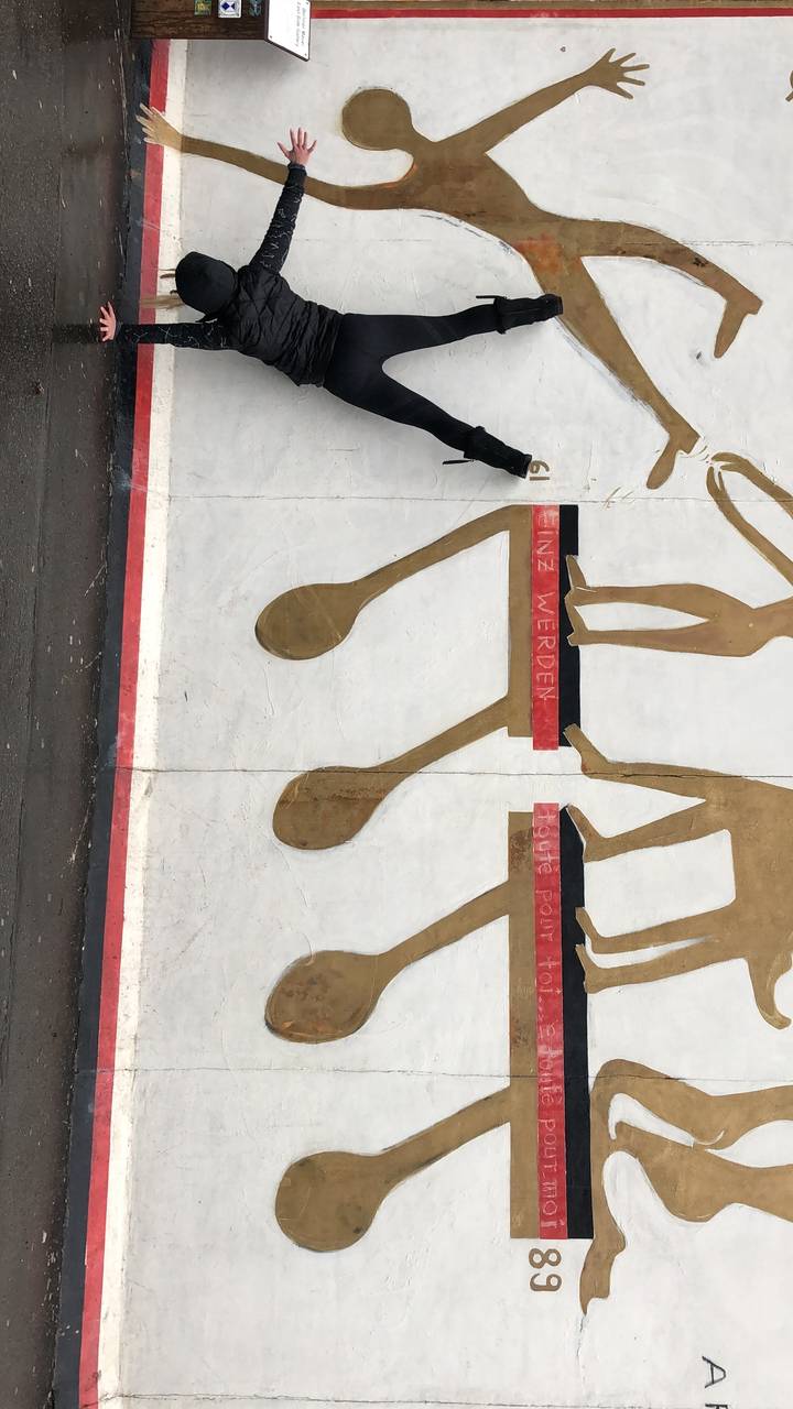 Personne faisant le poirier contre une fresque murale.