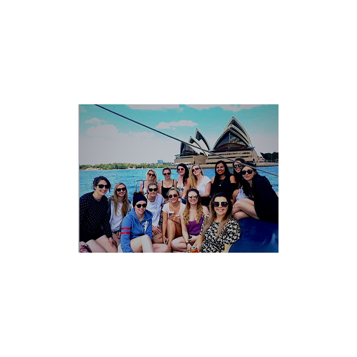 Group on a boat with the Sydney Opera House in the background.