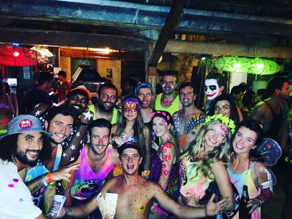 Large group of people at a vibrant party with neon paint.