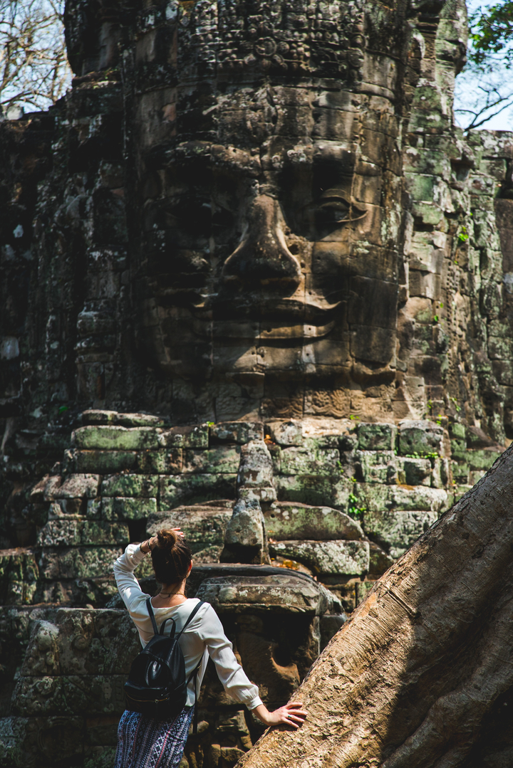 Close-up of a carved stone face in ancient ruins.