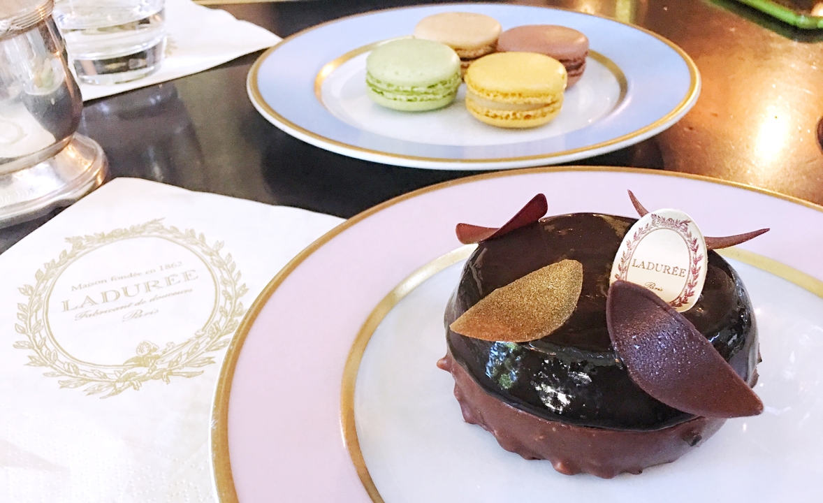 Desserts et macarons sur des assiettes dans une pâtisserie.