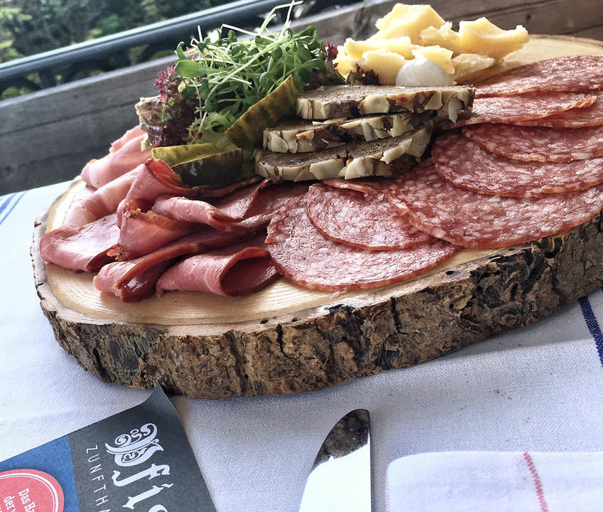 Un plateau de viandes assorties sur une planche en bois.
