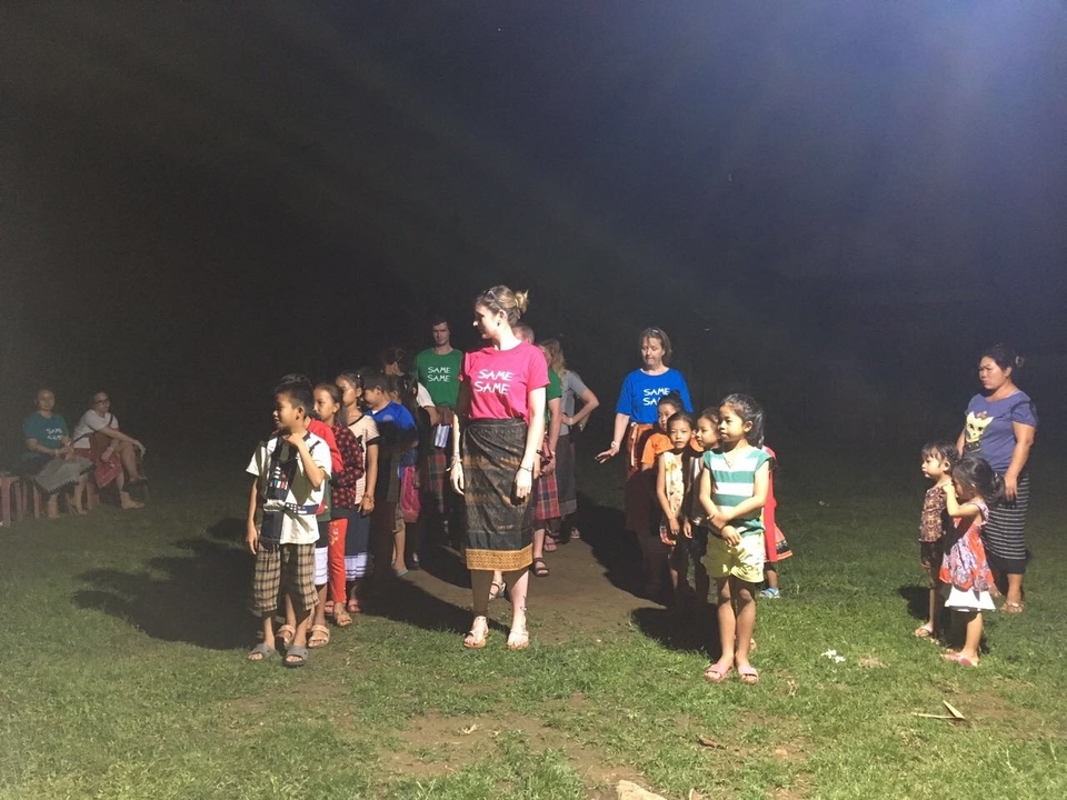 Enfants et adultes faisant la queue en plein air la nuit.