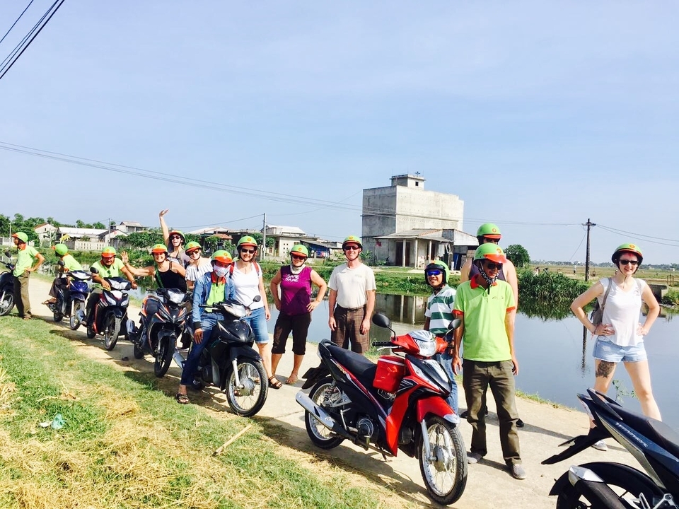 Groupe de personnes à moto sur une route de campagne.