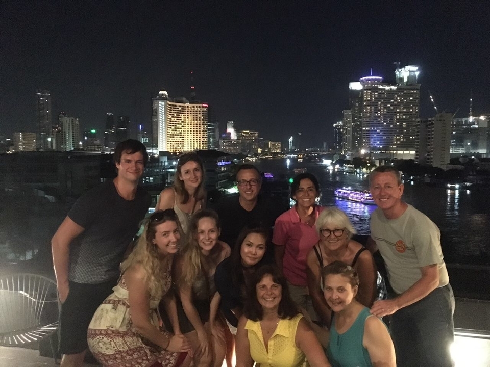 Photo de groupe de nuit avec la ligne d'horizon de la ville en arrière-plan.